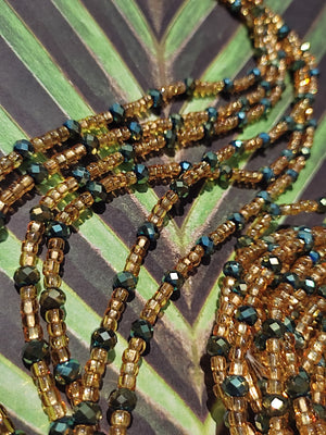 perles de verres doré avec cristal métalisé vert forêt à intervalle régulier sur la ligne de perles dorées. 